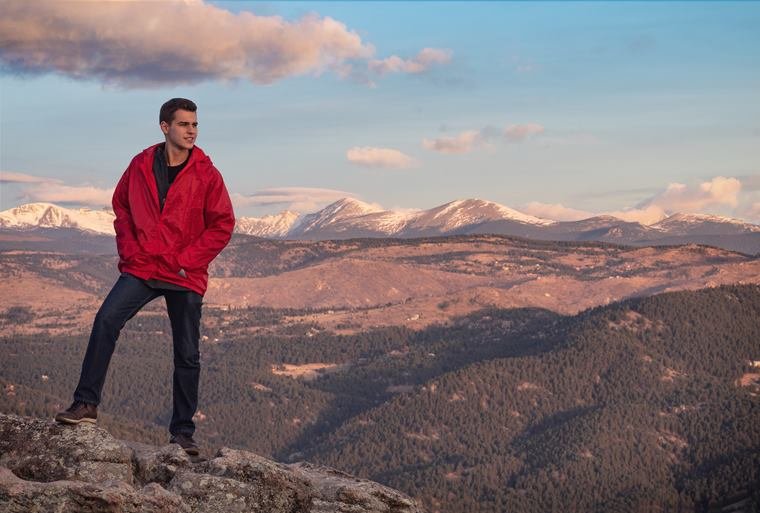 Portrait in a red jacket above the mountains